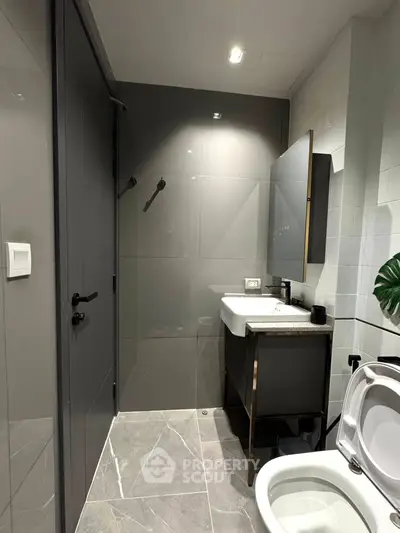 Modern bathroom with sleek design, featuring a stylish sink and toilet, perfect for contemporary living.