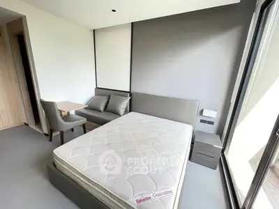 Modern bedroom with large window and stylish furniture in a contemporary apartment.