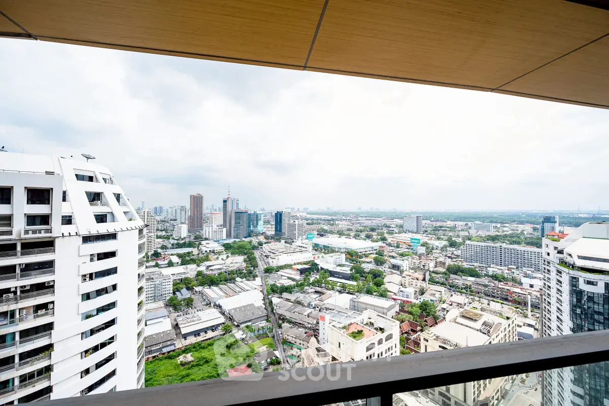 Stunning cityscape view from a high-rise balcony showcasing urban skyline and greenery.