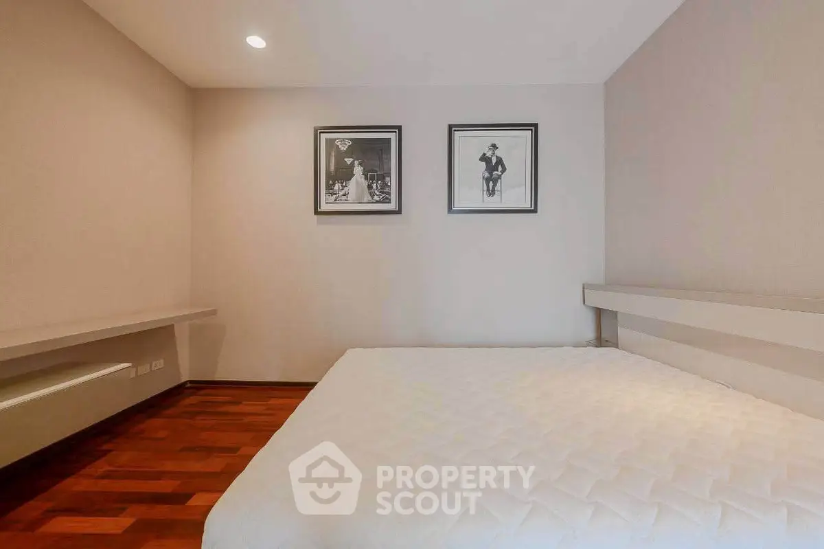 Spacious bedroom with elegant decor and hardwood flooring