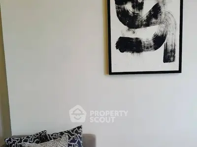 Modern living room with abstract art and stylish cushions, perfect for contemporary home decor.