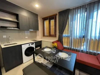 Modern living room with integrated kitchen featuring sleek cabinetry and cozy dining area.