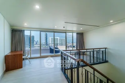 Spacious modern living room with city view and large balcony access.