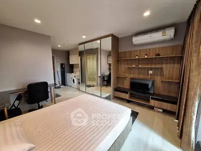 Modern bedroom with built-in wardrobe, TV, and compact kitchen area