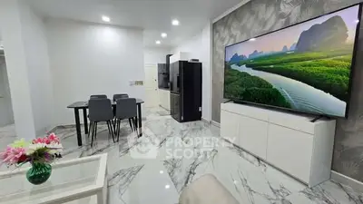 Modern living room with marble flooring, large TV, and elegant dining area.