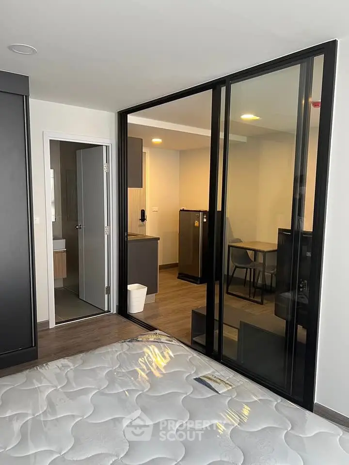Modern studio apartment with glass partition and sleek furnishings