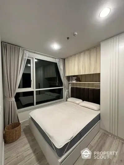 Modern bedroom with large bed, stylish wood paneling, and elegant drapery, complemented by soft lighting and a cozy atmosphere.