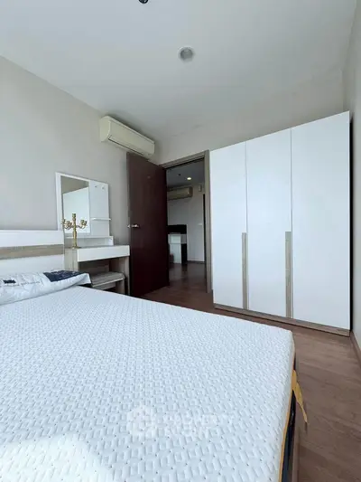 Modern bedroom with sleek wardrobe and air conditioning in a stylish apartment.