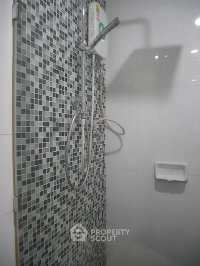 Modern bathroom shower with mosaic tiles and water heater
