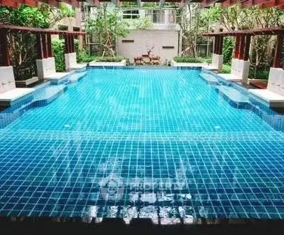 Luxurious swimming pool with serene surroundings in a modern residential complex.