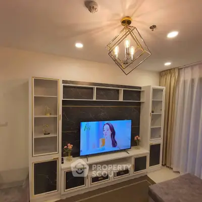 Luxurious living room with elegant TV unit and modern chandelier lighting.