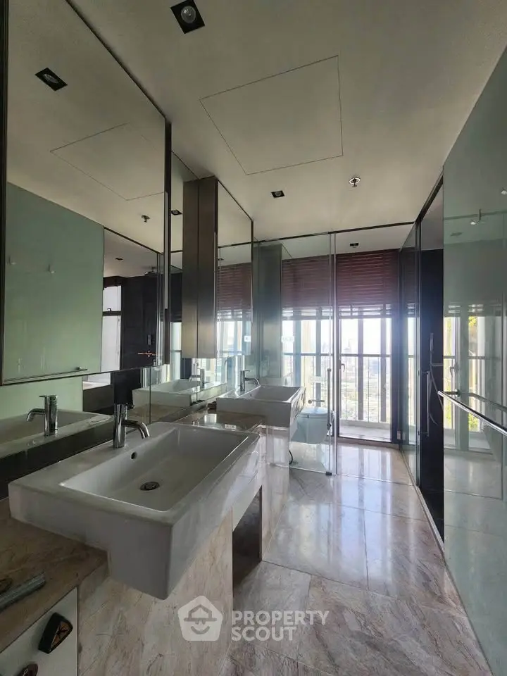 Luxurious modern bathroom with dual sinks and floor-to-ceiling windows offering stunning views.
