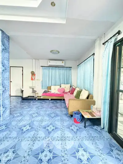 Spacious living room with vibrant blue tile flooring and cozy seating area.