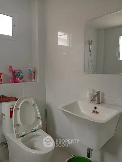Modern bathroom with sleek white fixtures and wall-mounted sink, perfect for a contemporary home.