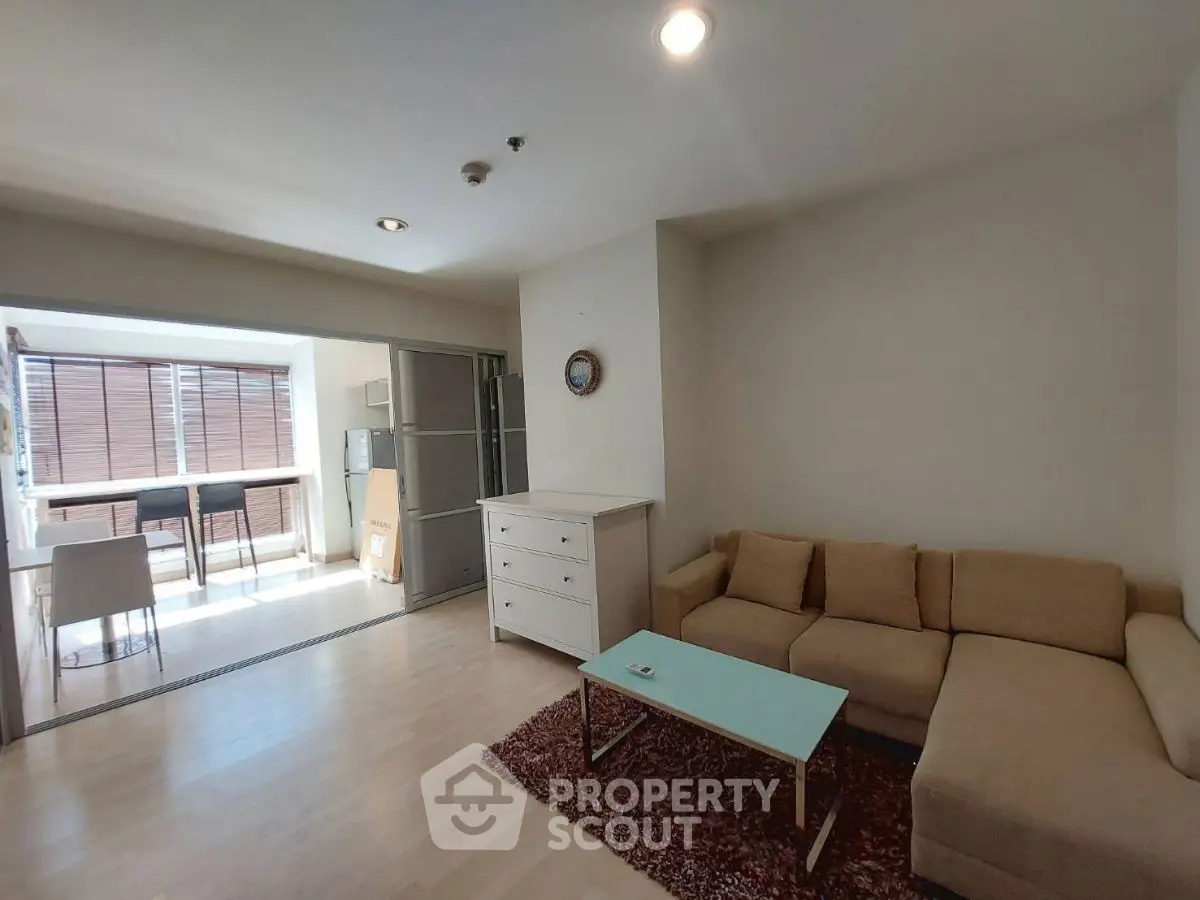 Spacious living room with natural light and modern furniture in a stylish apartment.