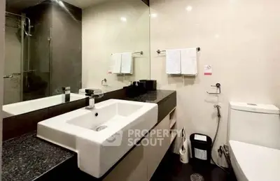 Modern bathroom with sleek fixtures and large mirror in contemporary home.