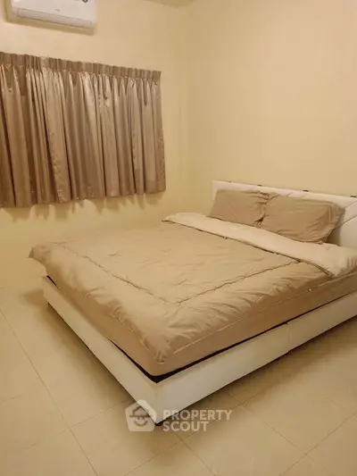Cozy bedroom with beige decor and air conditioning, perfect for restful nights.