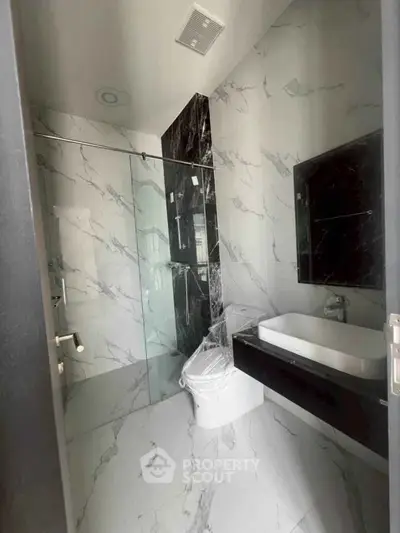 Luxurious modern bathroom with marble walls and sleek fixtures.