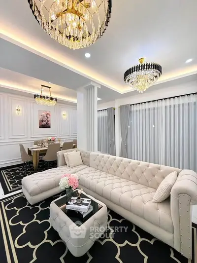 Luxurious living room with elegant chandeliers and plush furniture in a modern open layout.
