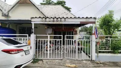 Charming suburban home with gated driveway and lush greenery.