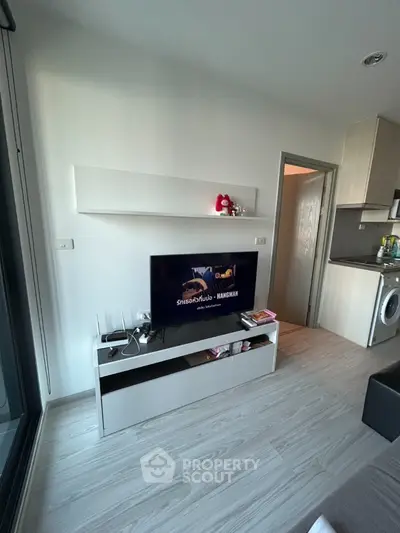 Modern living room with sleek TV setup and open kitchen layout
