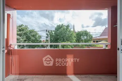 Spacious balcony with scenic view of lush greenery and distant architecture, perfect for relaxation.