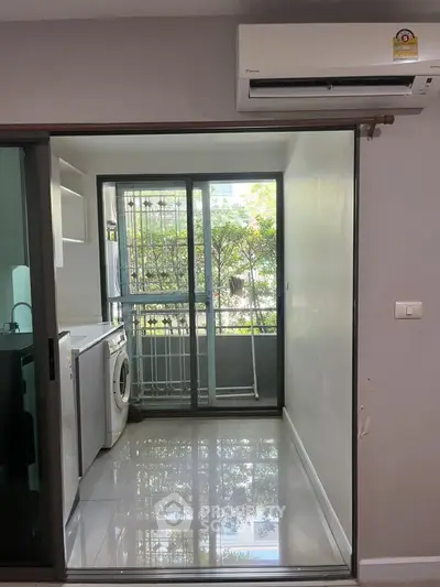 Modern laundry area with washing machine and sliding glass door