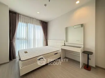 Modern bedroom with large window, elegant curtains, and sleek furniture in a bright apartment.