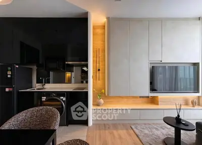 Modern living room with sleek black kitchen, integrated appliances, and stylish decor