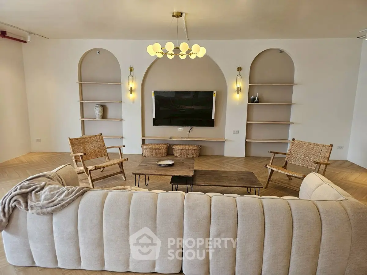 Elegant living room with modern decor and built-in shelves, featuring a cozy sofa and stylish lighting.