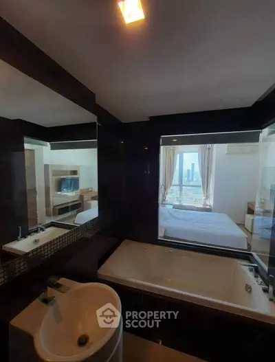 Luxurious bathroom with bathtub and city view from adjacent bedroom