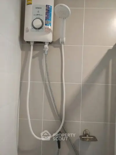 Modern bathroom with sleek shower unit and water heater, perfect for a comfortable living experience.