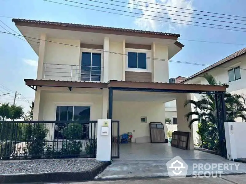 Modern two-story house with spacious driveway and lush greenery in a serene neighborhood.