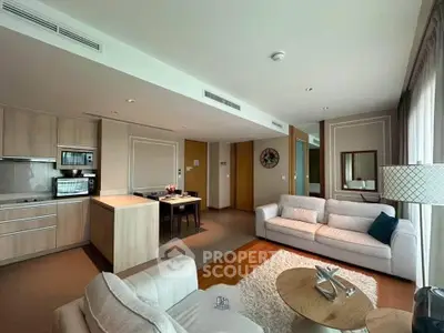 Modern living room with open kitchen, stylish furniture, and natural light.