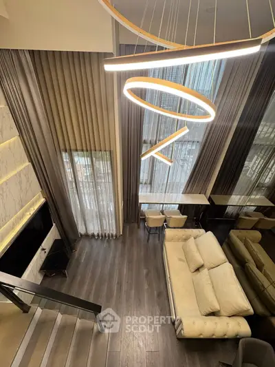 Luxurious modern living room with high ceilings, elegant lighting, and stylish furnishings in a contemporary apartment.