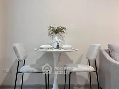 Chic modern dining area with elegant table setting and cozy seating in a stylish apartment.