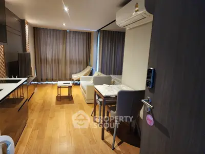 Modern living room with wooden flooring, stylish furniture, and air conditioning.