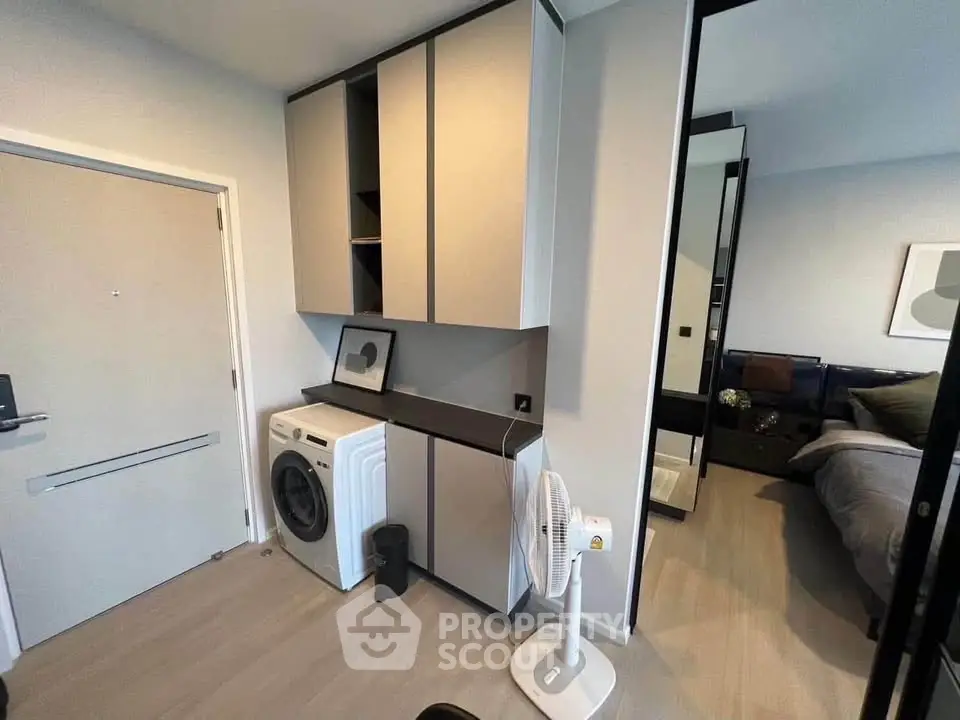 Modern apartment interior with washing machine and sleek storage cabinets