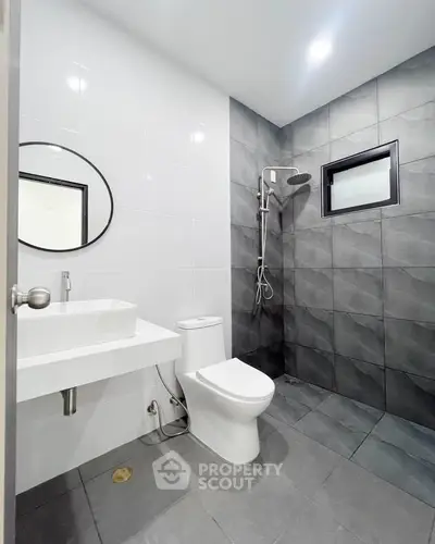 Modern bathroom with sleek design, featuring a walk-in shower and contemporary fixtures.