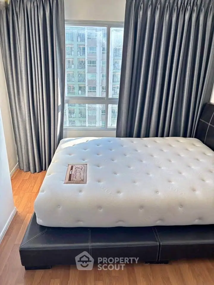 Modern bedroom with large window and stylish curtains in a high-rise apartment.