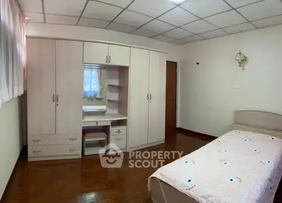 Spacious bedroom with wooden flooring and built-in wardrobe