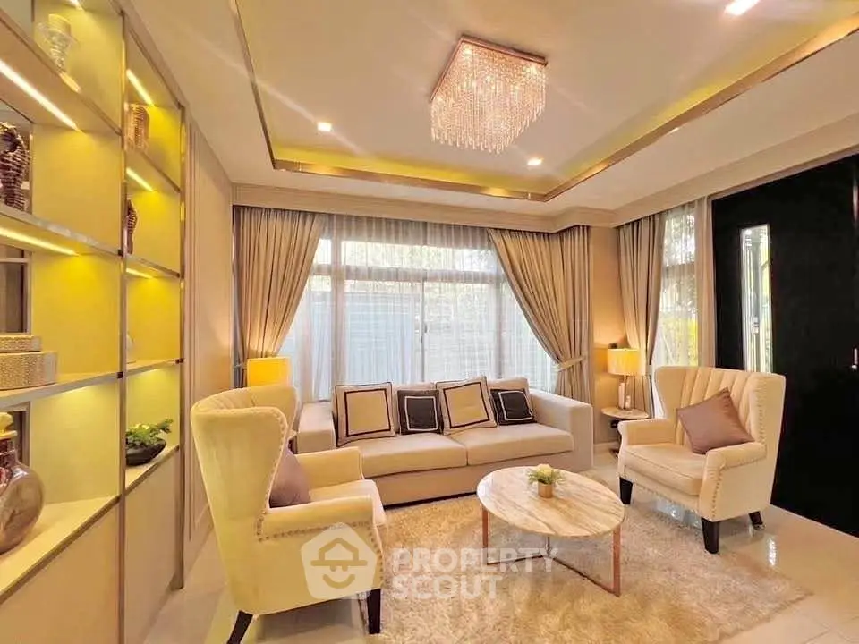 Luxurious living room with elegant chandelier and plush seating in a modern home.