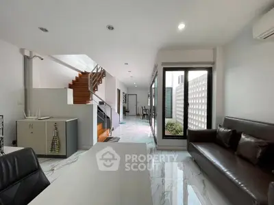 Modern living room with sleek design and staircase in contemporary home