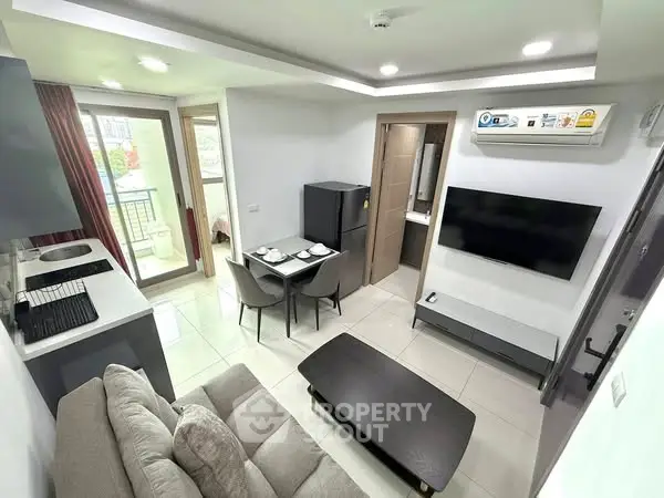 Modern living room with open kitchen and balcony access in a stylish apartment.