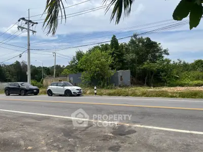 Vacant land plot with road access and lush greenery, ideal for development opportunities.