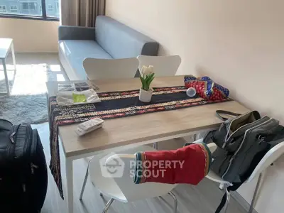 Modern living room with stylish dining table and cozy sofa, perfect for urban living.