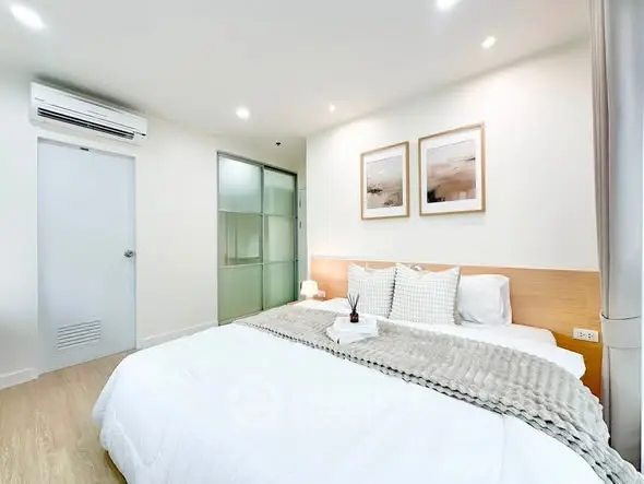 Modern bedroom with cozy decor and stylish lighting in a contemporary apartment.