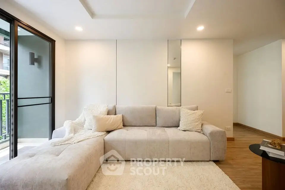 Modern living room with plush sofa and balcony view in a stylish apartment.