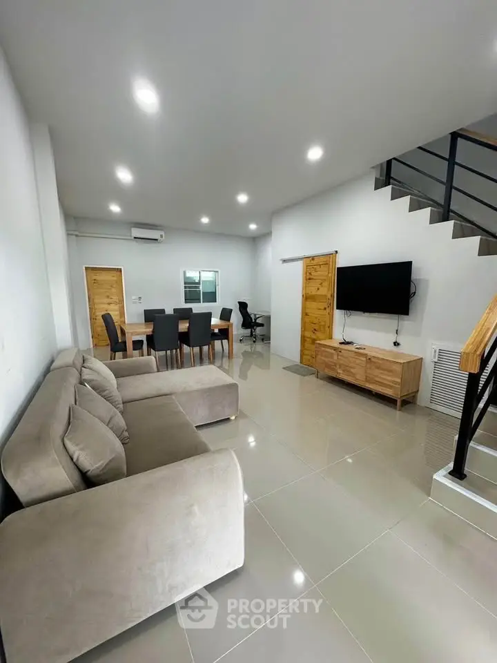 Spacious modern living room with sleek furniture and open dining area