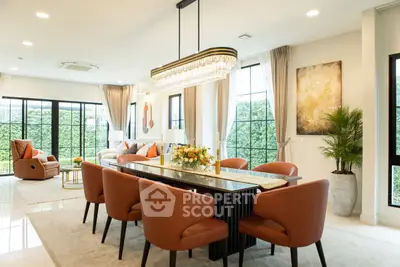 Luxurious open-plan living and dining area with elegant chandelier and modern decor.